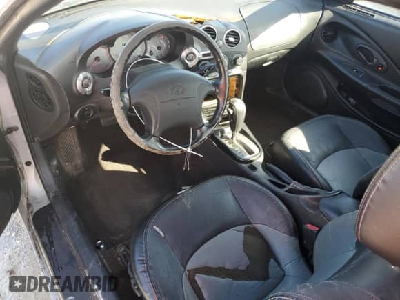 2001 Hyundai Tiburon с VIN KMHJG35F81U246024, выставлен на аукционе Copart как лот 77709294 с пробегом 127 057 миль миль и На запчасти • Non repairable. История ставок и продаж доступна на DreamBid. Изображение 8.