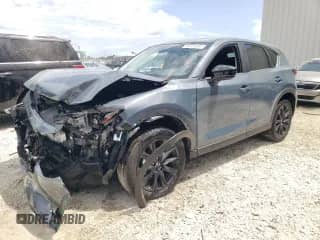 2025 Mazda CX-5 S Carbon Edition z VIN JM3KFBCM7S0681298, wystawiony jako Copart lot #69565385 z przebiegiem 9 552 mil mil oraz Czysty tytuł • Clean title. Historia ofert i sprzedaży dostępna na DreamBid. Obrazek 1.