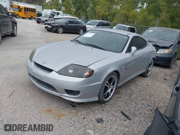 2005 Hyundai Tiburon GS z VIN KMHHM65D85U174335, wystawiony jako IAAI lot #39373771 z przebiegiem 117 296 mil mil oraz . Historia ofert i sprzedaży dostępna na DreamBid. Obrazek 2.