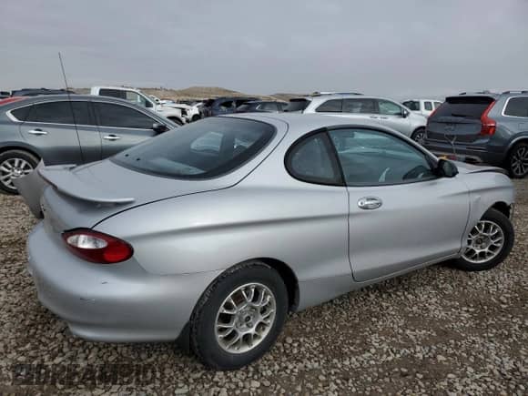 1999 Hyundai Tiburon с VIN KMHJG24F8XU126762, выставлен на аукционе Copart как лот 88747725 с пробегом 51 296 миль миль и Списание • Salvage title. История ставок и продаж доступна на DreamBid. Изображение 3.
