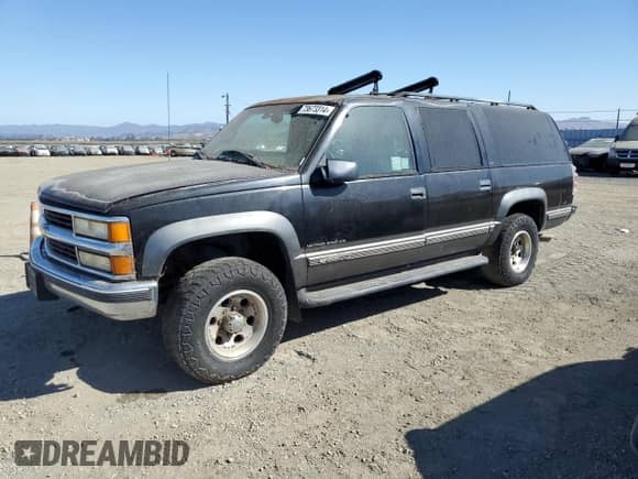 1999 Chevrolet Suburban z VIN 1GNGK26R5XJ513945, wystawiony jako Copart lot #73673314 z przebiegiem 198 656 mil mil oraz Czysty tytuł • Clean title. Historia ofert i sprzedaży dostępna na DreamBid. Obrazek 1.