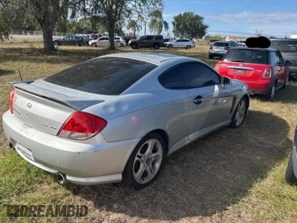 2005 Hyundai Tiburon GT z VIN KMHHN65F85U183258, wystawiony jako Copart lot #86871524 z przebiegiem 281 902 mil mil oraz Czysty tytuł • Clean title. Historia ofert i sprzedaży dostępna na DreamBid. Obrazek 4.