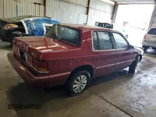 1991 Dodge Spirit z VIN 1B3XA46K7MF556659, wystawiony jako Copart lot #63274095 z przebiegiem 107 254 mil mil oraz Szkoda całkowita • Salvage title. Historia ofert i sprzedaży dostępna na DreamBid. Obrazek 3.