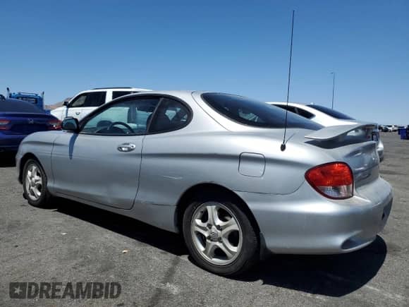2001 Hyundai Tiburon z VIN KMHJG25F11U258137, wystawiony jako Copart lot #63812855 z przebiegiem 27 682 mil mil oraz Czysty tytuł • Clean title. Historia ofert i sprzedaży dostępna na DreamBid. Obrazek 2.