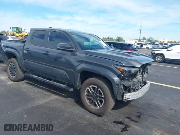 2024 Toyota Tacoma SR5 z VIN 3TYKB5FN6RT007410, wystawiony jako IAAI lot #43205199 z przebiegiem 26 768 mil mil oraz . Historia ofert i sprzedaży dostępna na DreamBid. Obrazek 1.