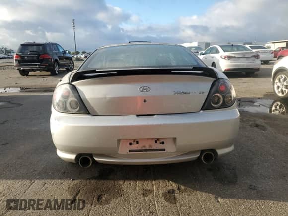 2006 Hyundai Tiburon GS z VIN KMHHM65D06U205823, wystawiony jako Copart lot #87125445 z przebiegiem 158 410 mil mil oraz Czysty tytuł • Clean title. Historia ofert i sprzedaży dostępna na DreamBid. Obrazek 6.