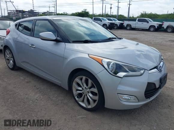 2012 Hyundai Veloster w/Gray Int z VIN KMHTC6AD8CU022989, wystawiony jako IAAI lot #42523328 z przebiegiem 169 005 mil mil oraz . Historia ofert i sprzedaży dostępna na DreamBid. Obrazek 1.
