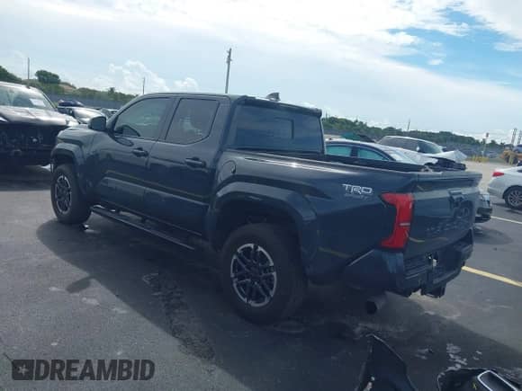 2024 Toyota Tacoma SR5 z VIN 3TYKB5FN6RT007410, wystawiony jako IAAI lot #43205199 z przebiegiem 26 768 mil mil oraz . Historia ofert i sprzedaży dostępna na DreamBid. Obrazek 3.