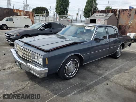 1984 Chevrolet Impala z VIN 1G1AL69H5EX151138, wystawiony jako Copart lot #81291035 z przebiegiem 21 974 mil mil oraz Szkoda całkowita • Salvage title. Historia ofert i sprzedaży dostępna na DreamBid. Obrazek 1.