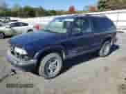2001 Chevrolet Blazer LS z VIN 1GNCT18W21K182784, wystawiony jako Copart lot #76004174 z przebiegiem 153 833 mil mil oraz Szkoda całkowita • Salvage title. Historia ofert i sprzedaży dostępna na DreamBid. Obrazek 1.