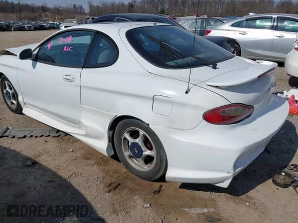 1998 Hyundai Tiburon z VIN KMHJG34F6WU115098, wystawiony jako IAAI lot #41718290 z przebiegiem 133 555 mil mil oraz . Historia ofert i sprzedaży dostępna na DreamBid. Obrazek 3.