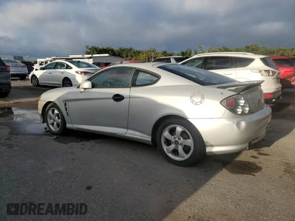 2006 Hyundai Tiburon GS z VIN KMHHM65D06U205823, wystawiony jako Copart lot #87125445 z przebiegiem 158 410 mil mil oraz Czysty tytuł • Clean title. Historia ofert i sprzedaży dostępna na DreamBid. Obrazek 2.
