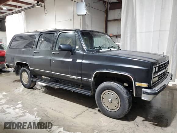 1990 Chevrolet Suburban z VIN 1GNGV26K0LF136318, wystawiony jako Copart lot #87379974 z przebiegiem 99 730 mil mil oraz Czysty tytuł • Clean title. Historia ofert i sprzedaży dostępna na DreamBid. Obrazek 4.