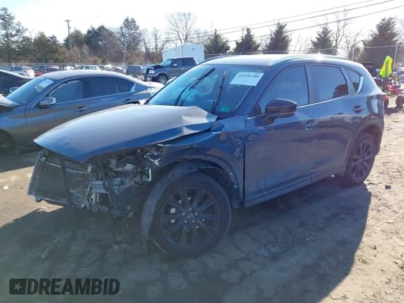 2022 Mazda CX-5 S Carbon Edition z VIN JM3KFBCM0N1561809, wystawiony jako IAAI lot #41428780 z przebiegiem 82 103 mil mil oraz . Historia ofert i sprzedaży dostępna na DreamBid. Obrazek 2.