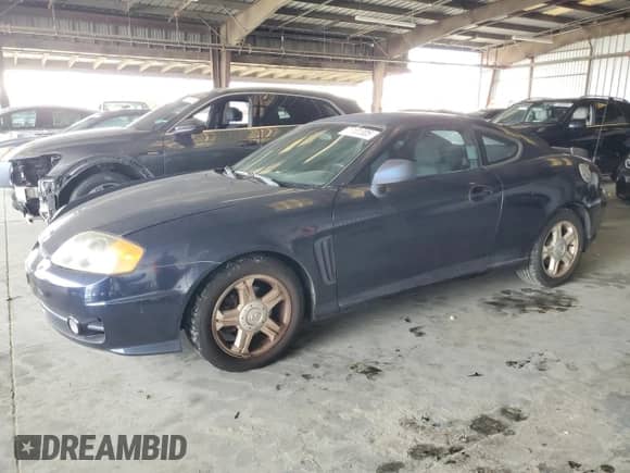2004 Hyundai Tiburon GS z VIN KMHHM65D04U107131, wystawiony jako Copart lot #72101305 z przebiegiem 136 073 mil mil oraz Szkoda całkowita • Salvage title. Historia ofert i sprzedaży dostępna na DreamBid. Obrazek 1.