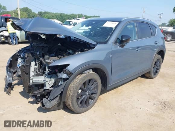 2022 Mazda CX-5 S Carbon Edition z VIN JM3KFBCM8N1565249, wystawiony jako IAAI lot #42739878 z przebiegiem 27 500 mil mil oraz . Historia ofert i sprzedaży dostępna na DreamBid. Obrazek 2.