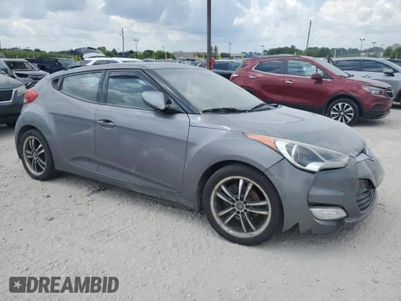 2012 Hyundai Veloster w/Red Int z VIN KMHTC6AD0CU053458, wystawiony jako Copart lot #60790585 z przebiegiem 123 096 mil mil oraz Czysty tytuł • Clean title. Historia ofert i sprzedaży dostępna na DreamBid. Obrazek 4.