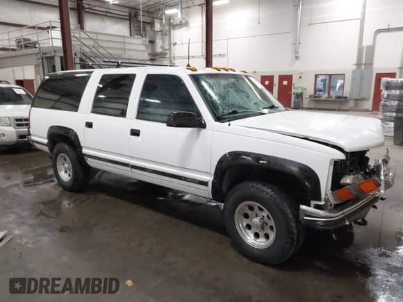 1993 Chevrolet Suburban z VIN 1GNFK16K1PJ330504, wystawiony jako IAAI lot #42194701 z przebiegiem 215 656 mil mil oraz . Historia ofert i sprzedaży dostępna na DreamBid. Obrazek 1.