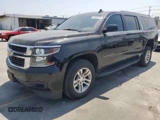 2019 Chevrolet Suburban LS with VIN 1GNSCGKC3KR231271, listed as a Copart auction lot 64438195 with 107,178 mi miles and Salvage title. Bid and sale history available at DreamBid. Image 1.