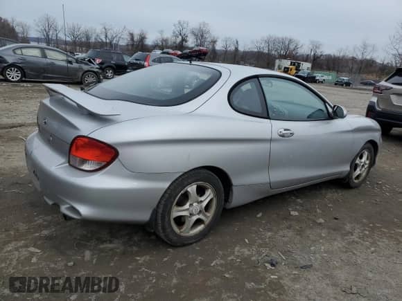 2001 Hyundai Tiburon с VIN KMHJG35F31U224416, выставлен на аукционе Copart как лот 83243684 с пробегом 59 473 миль миль и Списание • Salvage title. История ставок и продаж доступна на DreamBid. Изображение 3.