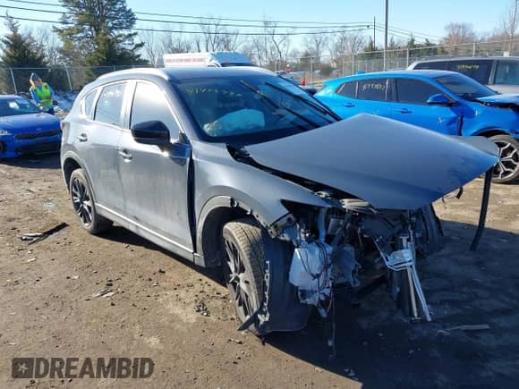 2022 Mazda CX-5 S Carbon Edition z VIN JM3KFBCM0N1561809, wystawiony jako IAAI lot #41428780 z przebiegiem 82 103 mil mil oraz . Historia ofert i sprzedaży dostępna na DreamBid. Obrazek 1.
