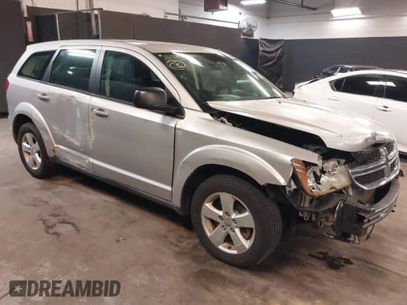 2013 Dodge Journey SE z VIN 3C4PDCAB7DT646083, wystawiony jako IAAI lot #42353530 z przebiegiem 117 965 mil mil oraz . Historia ofert i sprzedaży dostępna na DreamBid. Obrazek 1.