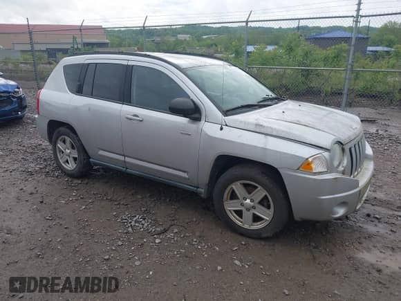2010 Jeep Compass Sport z VIN 1J4NT1FBXAD621049, wystawiony jako IAAI lot #42256736 z przebiegiem 99 000 mil mil oraz . Historia ofert i sprzedaży dostępna na DreamBid. Obrazek 1.