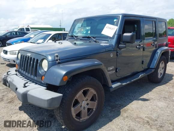 2007 Jeep Wrangler Unlimited Sahara z VIN 1J4GA59117L216687, wystawiony jako IAAI lot #42188257 z przebiegiem 176 507 mil mil oraz . Historia ofert i sprzedaży dostępna na DreamBid. Obrazek 2.