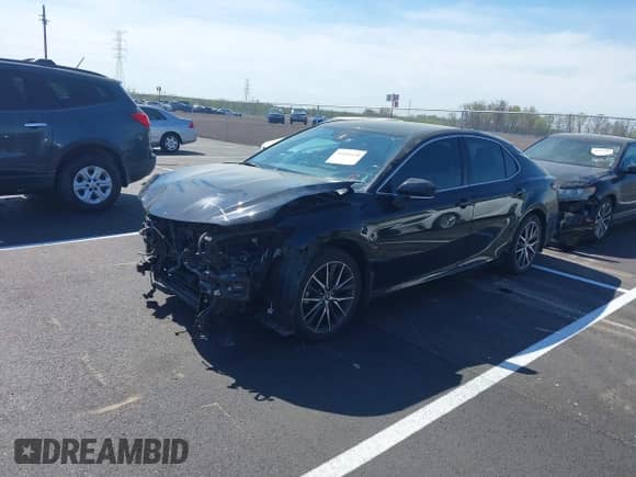 2022 Toyota Camry Hybrid XLE with VIN 4T1F31AK5NU594457, listed as a IAAI auction lot 41884438 with 69,767 mi miles and . Bid and sale history available at DreamBid. Image 2.
