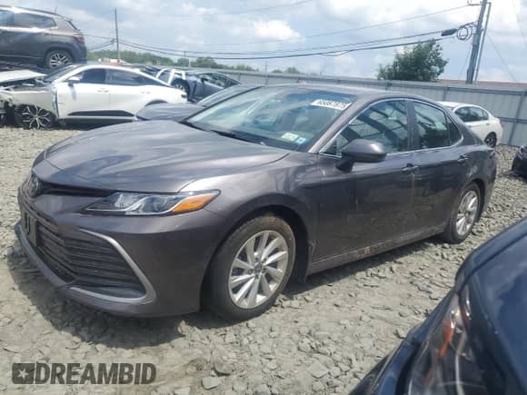 2023 Toyota Camry LE z VIN 4T1C11BK6PU102562, wystawiony jako Copart lot #65087875 z przebiegiem Nie podano mil oraz Szkoda całkowita • Salvage title. Historia ofert i sprzedaży dostępna na DreamBid. Obrazek 1.
