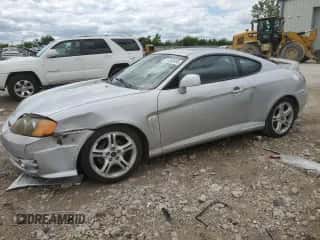 2004 Hyundai Tiburon GT z VIN KMHHN65F54U112744, wystawiony jako Copart lot #57850495 z przebiegiem 103 409 mil mil oraz Szkoda całkowita • Salvage title. Historia ofert i sprzedaży dostępna na DreamBid. Obrazek 1.