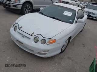 2000 Hyundai Tiburon z VIN KMHJG35F6YU167638, wystawiony jako IAAI lot #42335613 z przebiegiem 254 361 mil mil oraz . Historia ofert i sprzedaży dostępna na DreamBid. Obrazek 2.