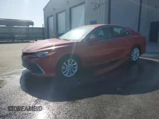 2023 Toyota Camry LE z VIN 4T1C11AK5PU115918, wystawiony jako Copart lot #85148995 z przebiegiem 57 491 mil mil oraz Czysty tytuł • Clean title. Historia ofert i sprzedaży dostępna na DreamBid. Obrazek 1.