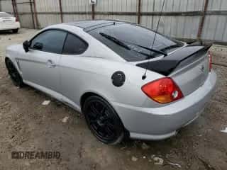 2003 Hyundai Tiburon GT z VIN KMHHN65F03U079618, wystawiony jako Copart lot #47642965 z przebiegiem 87 483 mil mil oraz Czysty tytuł • Clean title. Historia ofert i sprzedaży dostępna na DreamBid. Obrazek 2.