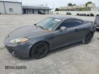 2007 Hyundai Tiburon GS z VIN KMHHM66D47U243846, wystawiony jako Copart lot #57509725 z przebiegiem 181 941 mil mil oraz Szkoda całkowita • Salvage title. Historia ofert i sprzedaży dostępna na DreamBid. Obrazek 1.