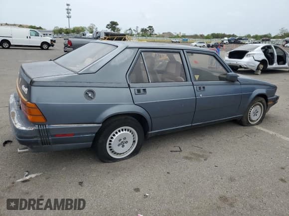 ✅ 1988 Alfa Romeo Milano • VIN: ZARDB1407J1250591 • Lot: 56344445. Listed on Copart with 7,703 mi. Free auction sales archive from the USA and detailed vehicle history report at DreamBid. Image 3.