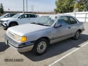 ✅ 1989 Ford Tempo • VIN: 1FAPP31X0KK113919 • Lot: 76599314. Listed on Copart with 65,823 mi. Free auction sales archive from the USA and detailed vehicle history report at DreamBid. Image 1.