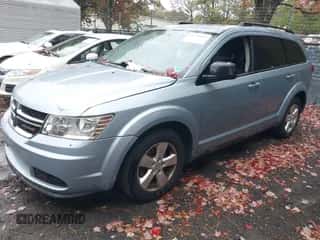 2013 Dodge Journey American Value z VIN 3C4PDCAB7DT587567, wystawiony jako IAAI lot #43556039 z przebiegiem 132 943 mil mil oraz . Historia ofert i sprzedaży dostępna na DreamBid. Obrazek 2.