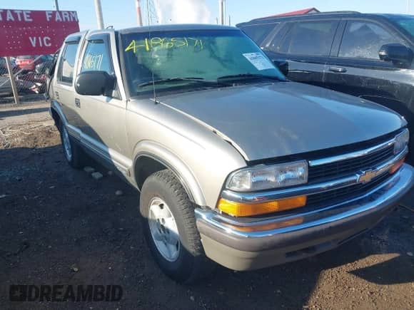 1999 Chevrolet Blazer LT z VIN 1GNDT13W9X2186755, wystawiony jako IAAI lot #41865171 z przebiegiem 107 191 mil mil oraz . Historia ofert i sprzedaży dostępna na DreamBid. Obrazek 1.