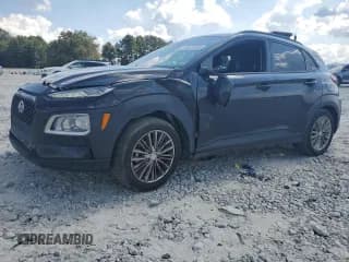 ✅ 2019 Hyundai Kona SEL • VIN: KM8K22AA9KU320074 • Лот: 80378655. Опубликован ранее на Copart с пробегом 101 573 миль. Бесплатный доступ к архиву аукционных продаж из США и подробный отчёт об истории автомобиля на DreamBid. Изображение 1.