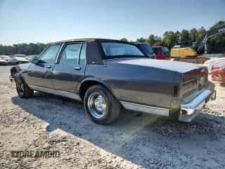 1985 Chevrolet Caprice z VIN 1G1BN69H6FY135833, wystawiony jako Copart lot #80281155 z przebiegiem 2 381 mil mil oraz Szkoda całkowita • Salvage title. Historia ofert i sprzedaży dostępna na DreamBid. Obrazek 2.
