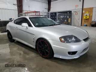 2006 Hyundai Tiburon GT z VIN KMHHN65F96U203924, wystawiony jako Copart lot #43624185 z przebiegiem 120 403 mil mil oraz Szkoda całkowita • Salvage title. Historia ofert i sprzedaży dostępna na DreamBid. Obrazek 4.